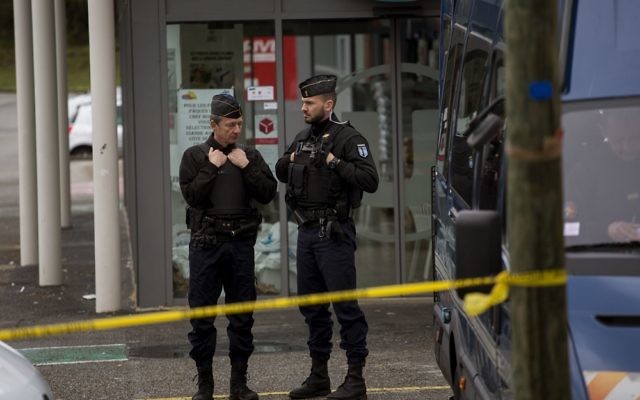 Police officers stand guard following an attack on a supermarket in Trebes, in southern France