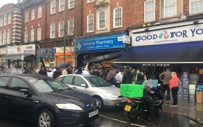 Pedestrians crowd around the pharmacy in Golders Green where the accident took place. 

Image posted by David Collier on Twitter