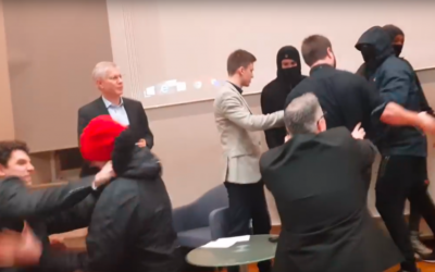 Screenshot of a video showing the antifa protesters storming the stage and confronting the moderator