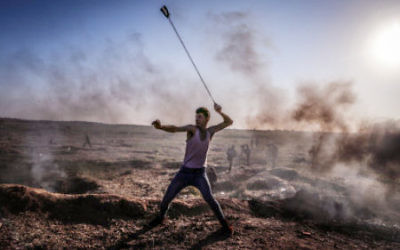 Palestinian demonstrator flings a rock in a slingshot towards Israeli positions (April 2018).