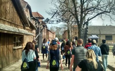 Members of the March of the Living UK Delegation walking through the famous - and notorious - gates at Auschwitz Berkanu