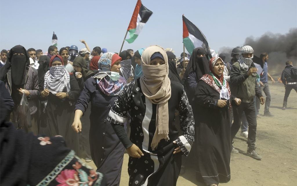 Palestinian women chant slogans as protesters burn tires near the Gaza Strip's border with Israel, east of Khan Younis, in the Gaza Strip, Monday, May 14, 2018. 
 (AP Photo/Adel Hana)