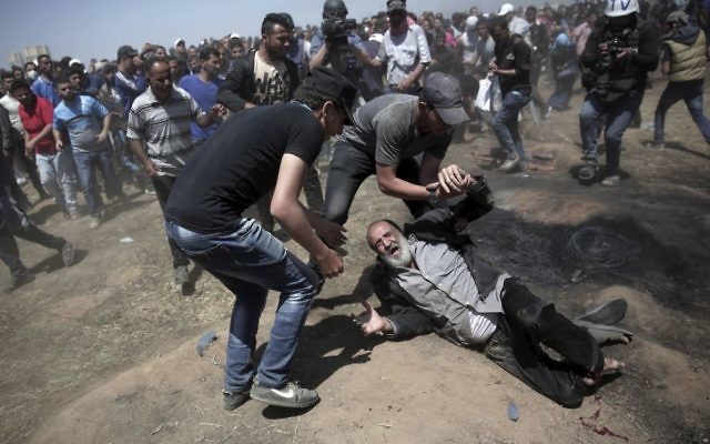 An elderly Palestinian man falls on the ground after being shot by Israeli troops during a deadly protest at the Gaza Strip's border with Israel, east of Khan Younis, Gaza Strip, 
(AP Photo/Adel Hana)