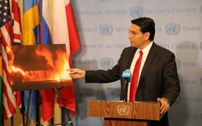 Danny Danon at the United Nations displaying a picture of the Gaza crossing used to bring in humanitarian aid, lit up in flames.