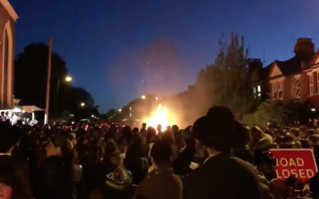 Orthodox community members watch on shortly after the explosion of the Lag Baomer fire

Screenshot from Youtube