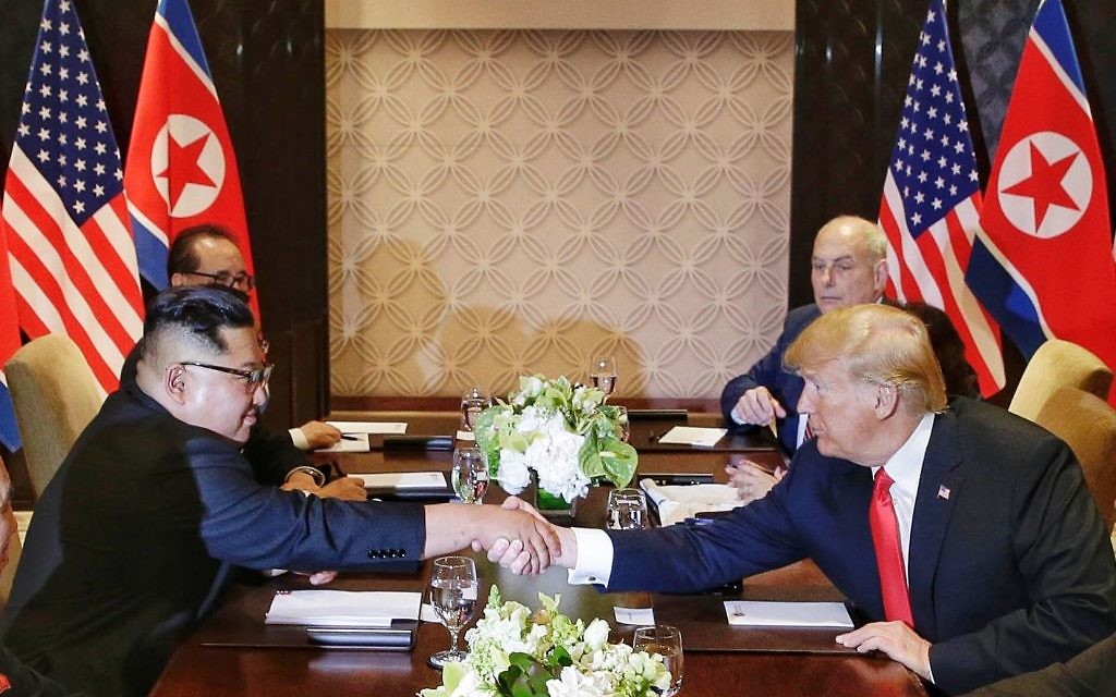 U.S. President Donald Trump shakes hands with North Korean leader Kim Jong Un during their meeting at the Capella resort on Sentosa Island in Singapore. (Kevin Lim/The Straits Times via AP)