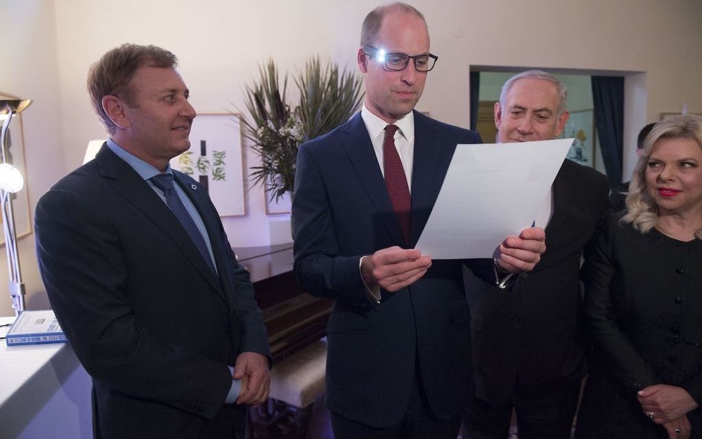 The Duke of Cambridge (centre), with Israeli Prime Minister Benjamin Netanyahu (right) and inventor Ziv Aviram (left) as he tries on glasses linked to a computer to help partially sighted people to see more clearly, during a Garden reception at the UK Ambassador to Israel in Tel Aviv, Israel 

Photo credit : Arthur Edwards/The Sun/PA Wire