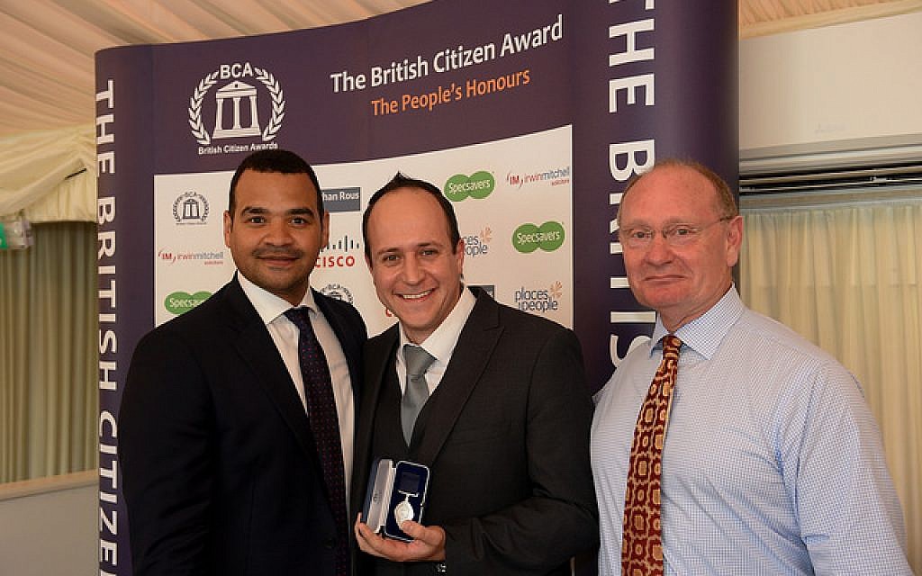 Dr Asher Lewinsohn (centre) collects his award, flanked by TV presenter and awards host Michael Underwood (left) and BCA Ambassador Des Benjamin (right)