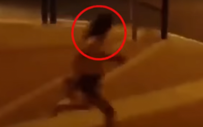 A screen capture from a video of a young woman being chased in Beit Shemesh by a group of ultra-Orthodox men over her "immodest" clothes. (Screen capture: YouTube)