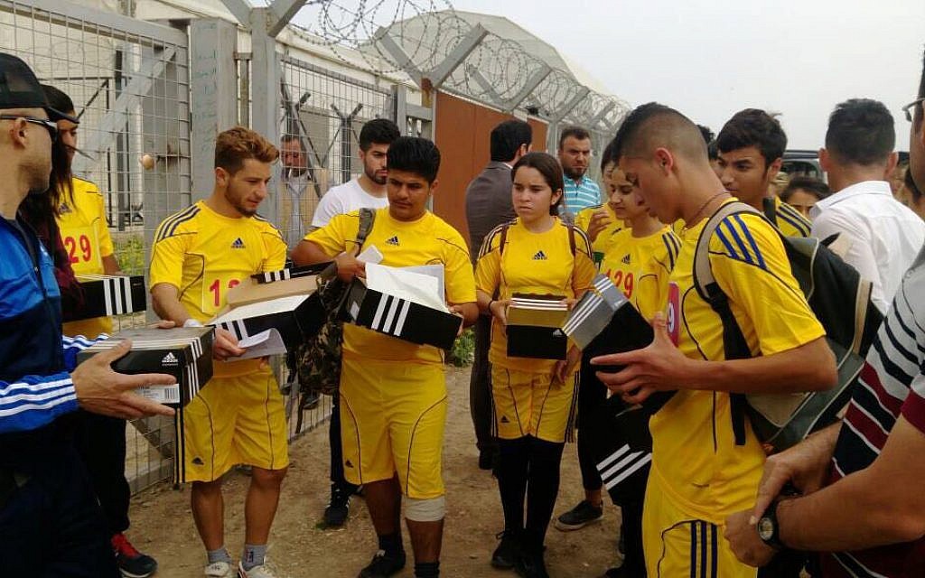Kurdish refugees open boxes of shoes donated through the campaign