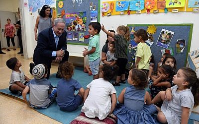 Israeli prime minister Bibi Netanyahu speaks with small children in a southern Israeli community