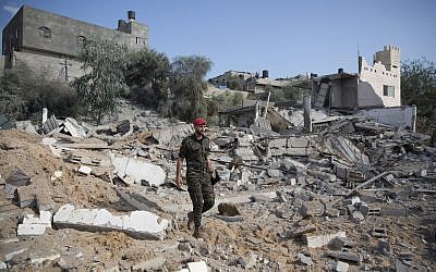 A Palestinian Hamas military policeman walks over the rubble of a site hit by Israeli airstrikes in Gaza City,  (AP Photo/Khalil Hamra)