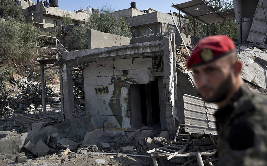 A Palestinian Hamas military policeman inspects the damage caused by Israeli airstrikes in Gaza City, Thursday, Aug. 9, 2018. Israel struck targets in the Gaza Strip after dozens of rockets were launched Wednesday from the coastal territory ruled by the Islamic militant Hamas group, the Israeli military said. (AP Photo/Khalil Hamra)