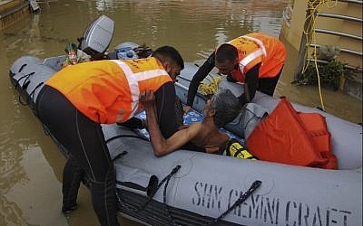 Indian military personnel rescue a flood affected man in the southern state of Kerala, (Indian Navy, via AP)