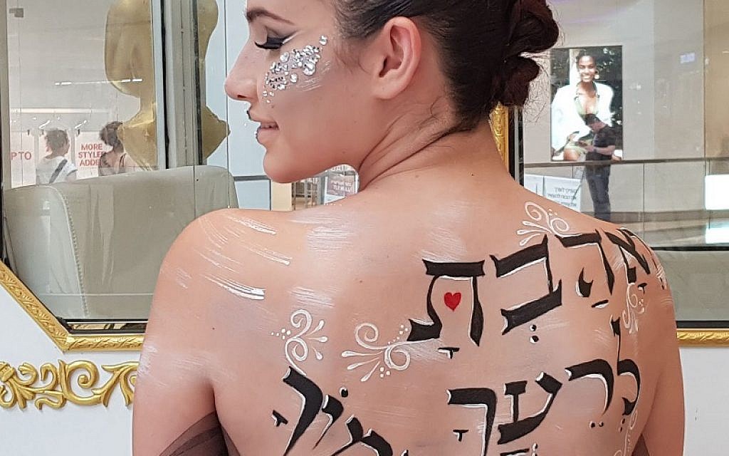 Message of love: A model is painted with the Hebrew words to 'love thy neighbour as thyself'