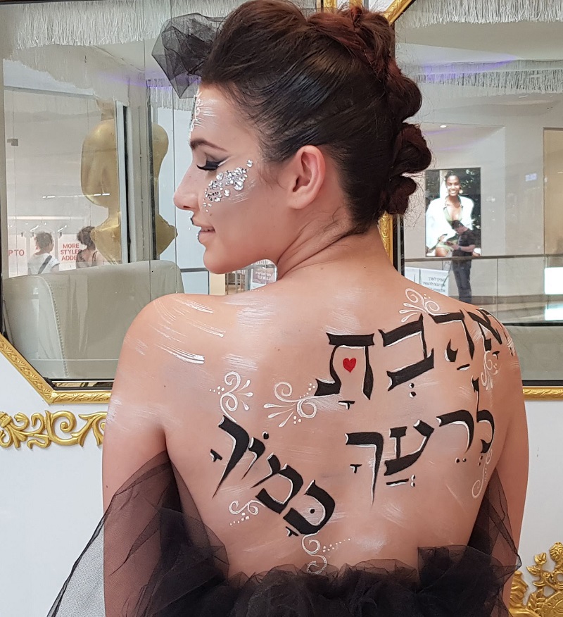 Message of love: A model is painted with the Hebrew words to 'love thy neighbour as thyself'