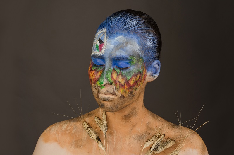 Michal Henig has used face paint to show Israel before and after the fire kite attacks by Hamas terrorists. Credit: Lilach Uzan