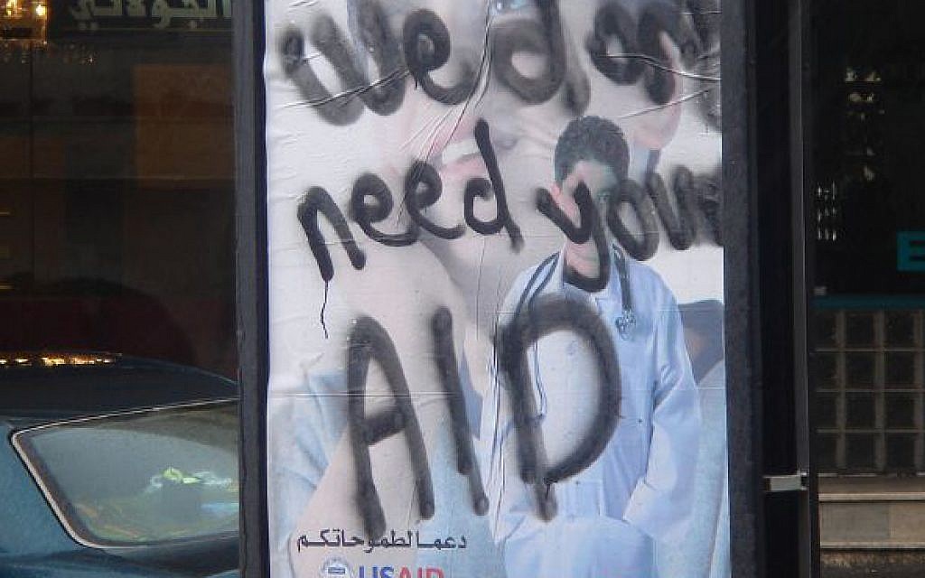 A poster in the West Bank from 2007 for USAID, daubed with graffiti on it saying "We don't need your AID"