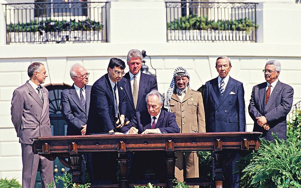 Minister of Foreign Affairs of Israel Shimon Peres puts his signature on the agreement during the signing ceremony of the historic Israeli-PLO Agreement, known as the Oslo 1 Accord, on the South Lawn of the White House in Washington, DC on September 13, 1993. Pictured, from left to right: From left to right are: Foreign Minister Andrei Kozyrev of Russia; Prime Minister Yitzhak Rabin of Israel; unknown aide; United States President Bill Clinton; Peres; Chairman Yasser Arafat of the Palestine Liberation Organization (PLO); US Secretary of State Warren Christopher; and Arafat aide Mahmoud Abbas. 

Credit: Arnie Sachs / CNP