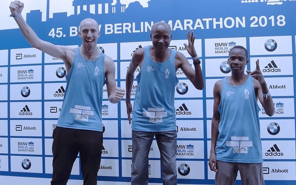 Athletes Fred Thackery-Vincent, Saidi Juma Makula  and Andrea Sipe Sambu on the podium, running for SACH