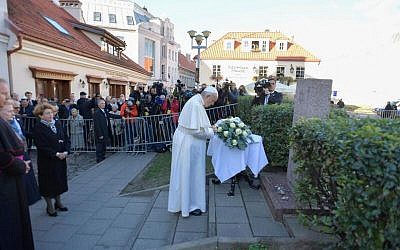Pope laying a wreath before praying at the site