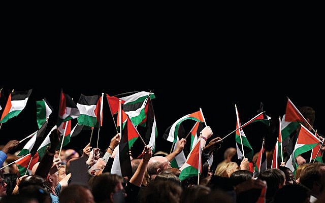 Delegates hold up Palestinian flags during a debate on the third day of the Labour party conference in Liverpool, September 2018  (Photo creditOLI SCARFF/AFP/Getty Images)