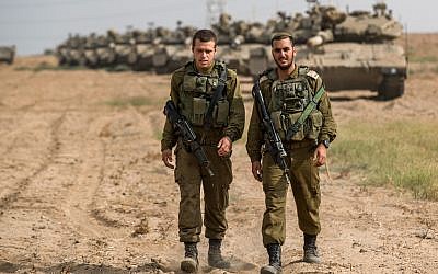 Israeli soldiers seen walking next to Merkava tanks that are stationed in an open area near Israel's border with the Gaza Strip on October 19, 2018  Photo by: JINIPIX