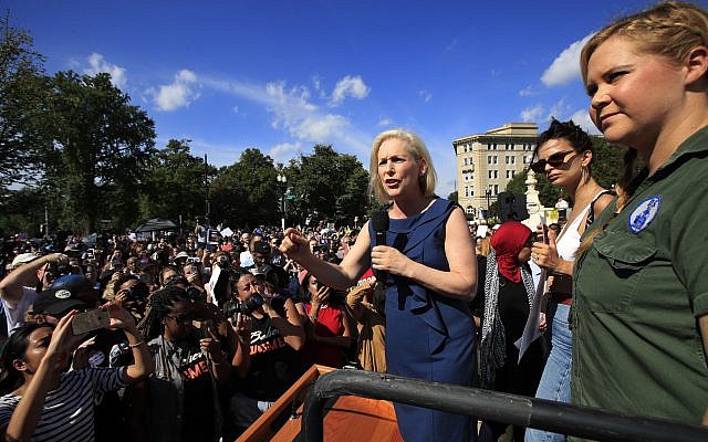 Sen. Kirsten Gillibrand, with actress and comedian Amy Schumer, right, and actress model Emily Ratajkowski, centre, speaks at a rally against Supreme Court nominee Brett Kavanaugh at the Supreme Court in Washington (AP Photo/Manuel Balce Ceneta)