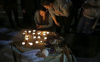 People light candles  in Tel Aviv, Israel, in a commemoration of the victims of a deadly shooting at a Pittsburgh synagogue, Sunday, Oct. 28, 2018. (AP Photo/Ariel Schalit)