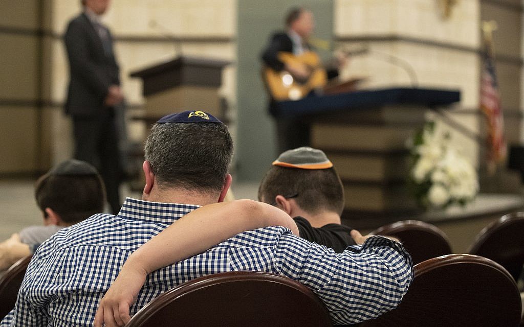 People gather at the B'nai Aviv Synagogue in Weston, Fla., Sunday, Oct. 28, 2018, after Saturday's shooting that took place during worship services inside Tree of Life Synagogue in Pennsylvania. (Jennifer Lett/South Florida Sun-Sentinel via AP)