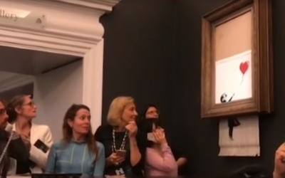 Screenshot from YouTube video showing Bansky shredding his own artwork