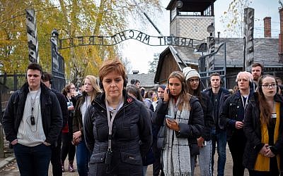 Nicola Sturgeon at Auschwitz, in front of the gate reading 'Work sets you free - Arbeit macht frei' (Credit: Holocaust Educational Trust)