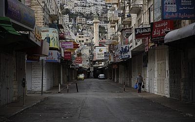 A Palestinian man walks in front of closed shops during a general strike in protest of the recently passed Jewish nation state law in Israel. in the old city of Nablus in the West Bank. (AP Photo/Majdi Mohammed)