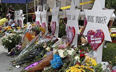 Flowers surround Stars of David as part of a makeshift memorial outside the Tree of Life Synagogue to the 11 people killed during worship services Saturday Oct. 27, 2018 in Pittsburgh. (AP Photo/Gene J. Puskar)