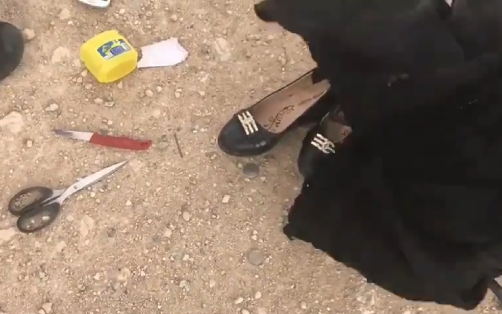 Police go through belongings of woman after she was shot while attacking a soldier. Included in her bag, is a knife with a red handle and a pair of scissors.  credit: @LocalFocus1 on Twitter
