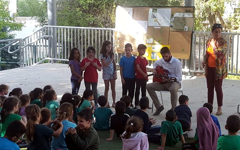 Jack Omer-Jackaman playing guitar at Neve Shalom - Oasis of Peace.  Credit: @oasis_of_peace