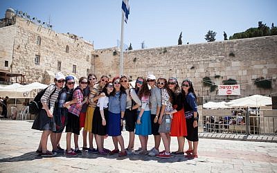 Teenage girls on tour in Israel posing in front of the Western Wall