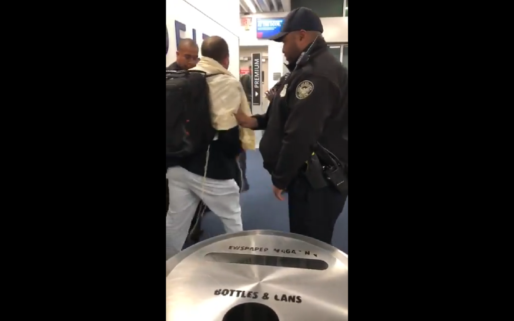 Screenshot of the man in a talit being seen to by police after being abusive