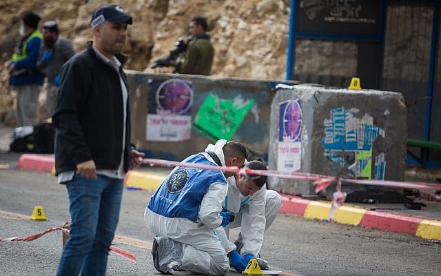 Israeli forces and forensics inspect the site of a Palestinian drive-by shooting attack outside the West Bank settlement of Givat Asaf, northeast of Ramallah, on December 13, 2018. - Two Israelis were killed and at least two others were wounded at the bus stop in the occupied West Bank, the army said. "A Palestinian opened fire at a bus stop killing 2 Israelis, severely injuring 1 & injuring others at Asaf Junction, north of Jerusalem," the Israeli military said on its Twitter account. Photo by: JINIPIX