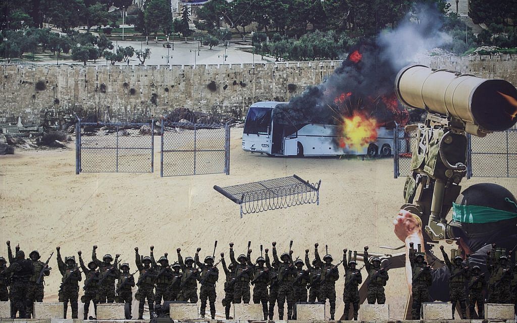 Masked gunmen of the al-Qassam brigades, the military wing of Hamas, raise their hands as they stand in front of a huge poster showing a mock attack on a bus, during a mass rally marking the 31st anniversary of the founding of Hamas, an Islamic political party, that currently rules in Gaza, Sunday, Dec. 16, 2018, in Gaza city. (AP Photo/Khalil Hamra)