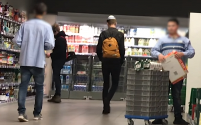 Screenshot from the YouTube video, showing a man with a kippah walking through a supermarket