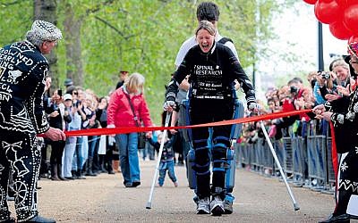 Claire crossing the finish line in London in her ReWalk suit.