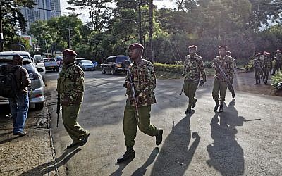 Security forces walk to the scene as continued blasts and gunfire could be heard early Wednesday, Jan. 16, 2019 in Nairobi, Kenya.  (AP Photo/Ben Curtis)