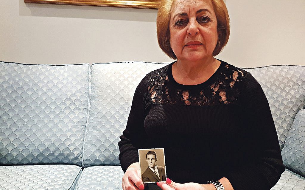 Faiza Saigh holding a photo of her brother, Daoud Ghali Yadgar