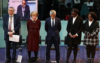 Tony Arbour, Susan Pollack, Sadiq Khan, and two young students who read passages during the ceremony, bow their heads in remembrance during the ceremony.