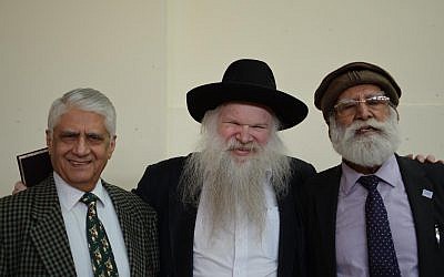 Rabbi Herschel Gluck with two guests at the exhibition