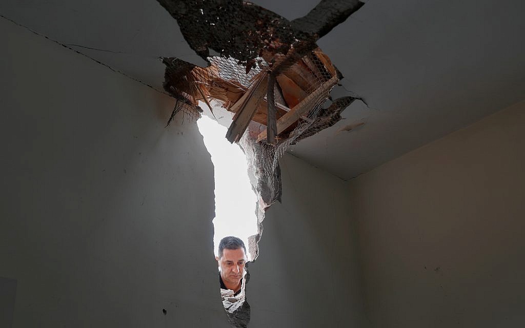 A man examines damage to a house after it was hit by a rocket on Monday in Sderot, southern Israel.  Photo by: JINIPIX