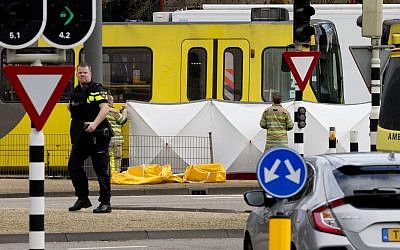 Rescue workers install a screen on the spot where a body was covered with a white blanket following a shooting in Utrecht (AP Photo/Peter Dejong)