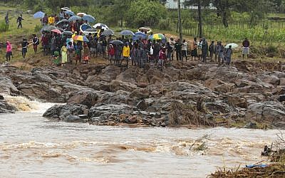 Schoolchildren are stranded across a collapsed bridge in Chimanimani, southeast of Harare, Zimbabwe, Monday, March 18, 2019. (AP Photo/Tsvangirayi Mukwazhi)