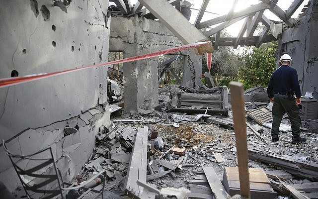 A police officer inspects the damage to a house hit by a rocket in Mishmeret, central Israel. (AP Photo/Ariel Schalit)